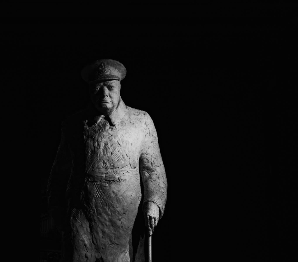 A powerful black and white photograph of a Winston Churchill statue in Paris, France.