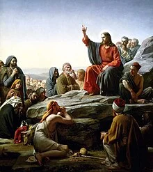 Artist rendering of Jesus Christ giving a Sermon on the Mount. Sitting on a rock with may listener sitting around him.