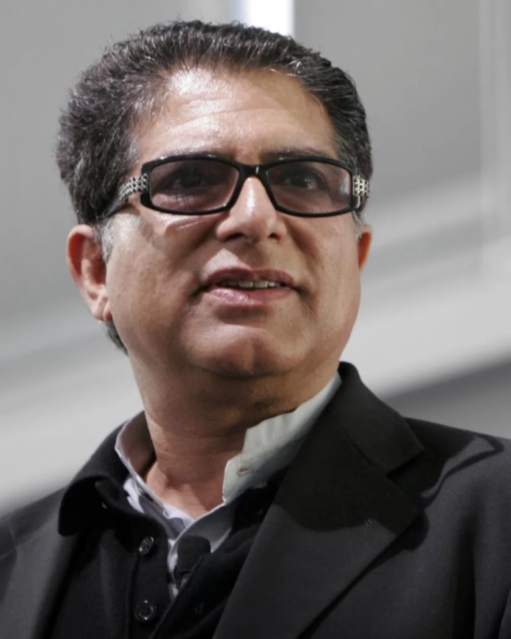 Head shot of Deepok Chopra wearing a vest and sport coat no tie.